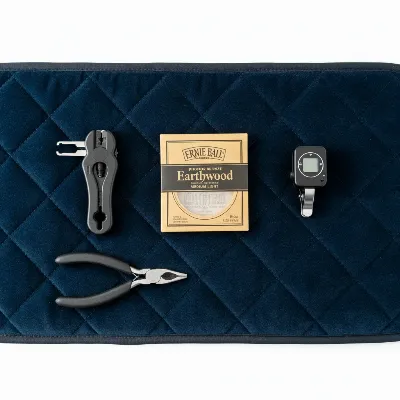 Essential tools for changing acoustic guitar strings: winder, cutters, tuner, new strings